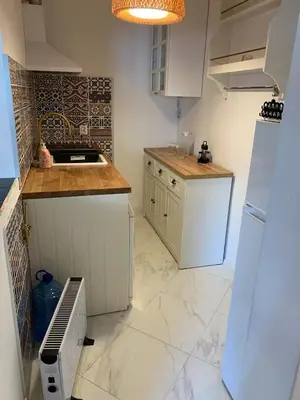 a kitchen with white cabinets and a tile floor at Urban Nest Lulin in Sofia
