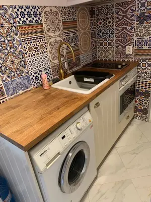 a kitchen with a sink and a washing machine at Urban Nest Lulin in Sofia