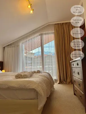 a bedroom with a bed and a large window at Luxfjäll Ivan Rilski - Full Spa & Pool in Bansko