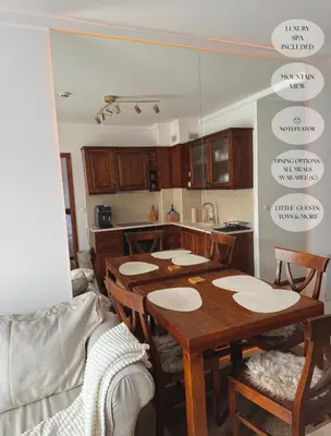 a kitchen with a table and chairs and a kitchen with descriptions of the tables at Luxfjäll Ivan Rilski - Full Spa & Pool in Bansko