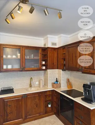 a kitchen with wooden cabinets and a sink at Luxfjäll Ivan Rilski - Full Spa & Pool in Bansko