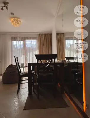 a dining table and chairs in a living room at Luxfjäll Ivan Rilski - Full Spa & Pool in Bansko