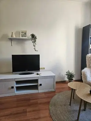 a living room with a flat screen tv on a white cabinet at City Center Park Apartment in Sofia