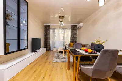 a living room with a table and a couch at Two-Bedroom Apartments with Free Private Parking and 6min to Center in Plovdiv