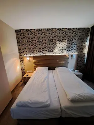 a large bed in a room with a wall at ВасиленаАпарт in Pamporovo
