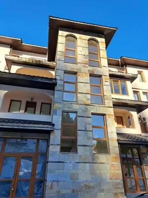 a building with windows on the side of it at Георгиев Луксури Апарт in Pamporovo