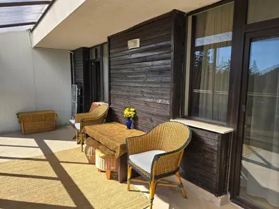 a patio with a wooden table and chairs on a porch at Pampo-Heaven in Smolyan