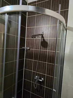 a shower in a bathroom with brown tiles at Pampo-Heaven in Smolyan