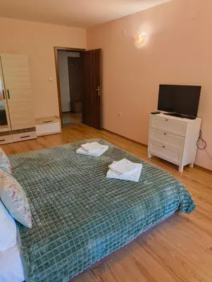 a bedroom with a bed and a dresser with a television at Evrika home 4 in Pamporovo