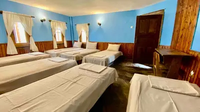 a room with four beds and blue walls and windows at Туристическа спалня Богдан in Koprivshtitsa