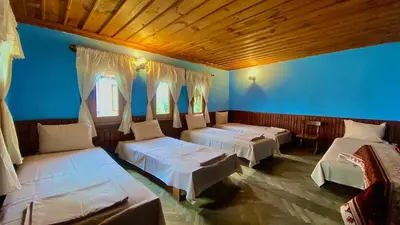 a room with three beds and a blue wall at Туристическа спалня Богдан in Koprivshtitsa