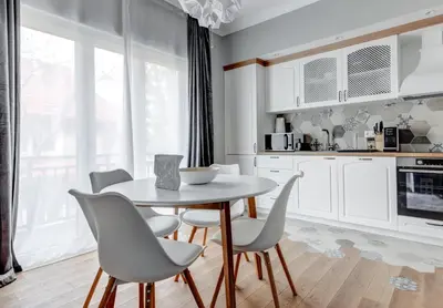 a kitchen with white cabinets and a table and chairs at Quiet One-Bedroom Hеaven Relax and Unwind in Sofia