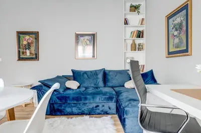 a living room with a blue couch and a table at Quiet One-Bedroom Hеaven Relax and Unwind in Sofia