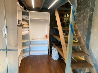 a staircase leading to a closet with wooden shelves at Graf's Prestige Duplex in Sofia