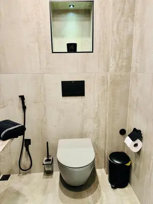 a bathroom with a white toilet and a mirror at luxuri suite ''dezodava'' in Sandanski