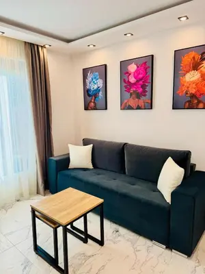 a living room with a blue couch and a table at luxuri suite ''dezodava'' in Sandanski