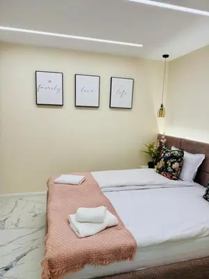 a bedroom with a bed with two towels on it at luxuri suite ''dezodava'' in Sandanski
