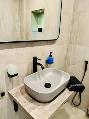 a white sink in a bathroom with a mirror at luxuri suite ''dezodava'' in Sandanski