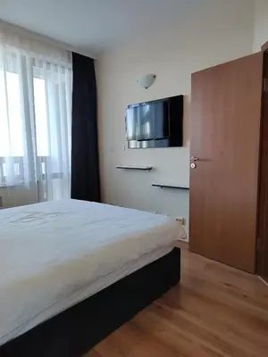 a bedroom with a bed and a tv on the wall at Mountain Ski & SPA apartment in Pamporovo