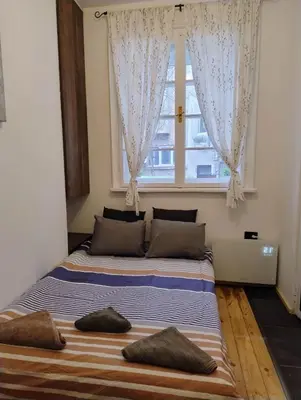a bedroom with two beds in front of a window at Tiny studio in top center in Sofia