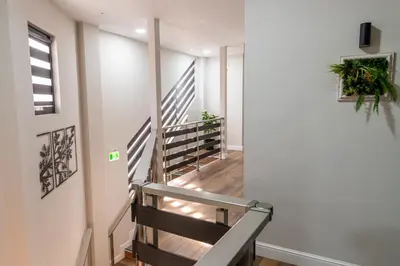 a staircase in a home with white walls and wood floors at Семеен Хотел Олимп in Sopot