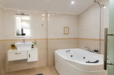 a bathroom with a white tub and a sink at Семеен Хотел Олимп in Sopot
