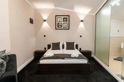 a bedroom with a bed and a glass wall at Семеен Хотел Олимп in Sopot