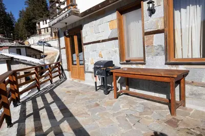 a wooden table on a patio next to a building at Комплекс БОЖИДАРИЦА in Progled
