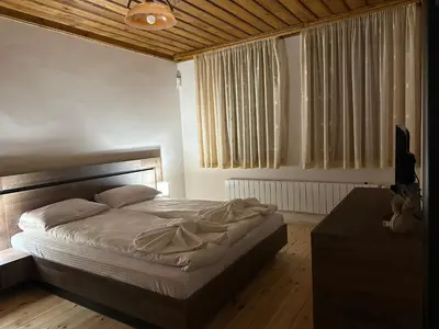 a bedroom with a large bed and a table at Комплекс БОЖИДАРИЦА in Progled
