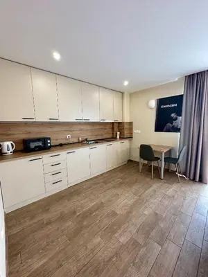 a kitchen with white cabinets and a table in a room at Music Flats in Sofia