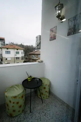 a table and two stools in a room with a window at Top Center in Blagoevgrad