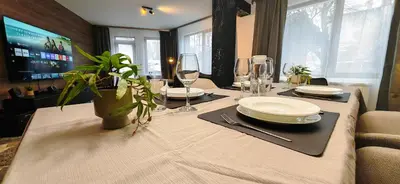 a table with plates and glasses and a plant on it at Modern apartment with terrace in Chepelare