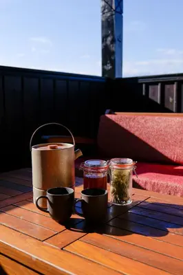 a wooden table with two cups and jars on it at Трите къщи in Leshten