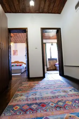 a room with two doors and a rug on the floor at Трите къщи in Leshten