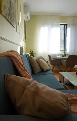 a living room with a blue couch and a table at S íRMA Apartment - Next to the Old Cathedral in Sofia