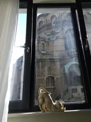 a statue of a cat sitting on a window sill at S íRMA Apartment - Next to the Old Cathedral in Sofia