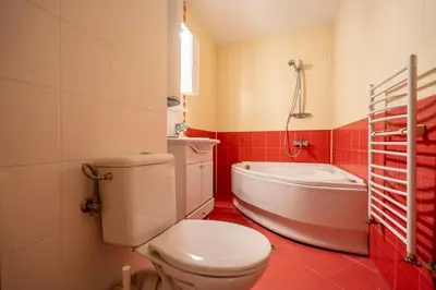 a bathroom with a white toilet and a bath tub at Central Sofia Retreat in Sofia