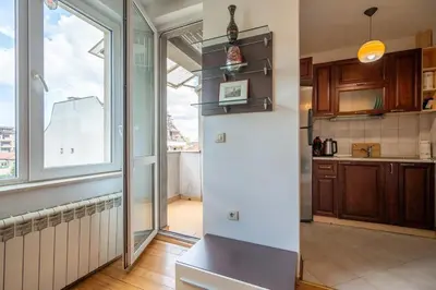 a kitchen with a refrigerator and a large window at Central Sofia Retreat in Sofia