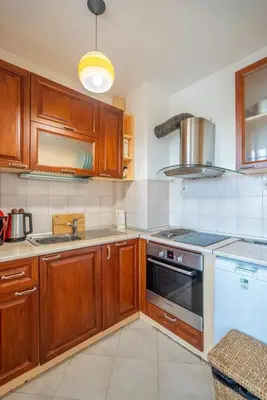 a kitchen with wooden cabinets and a stove top oven at Central Sofia Retreat in Sofia
