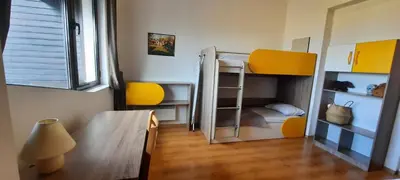 a room with a bunk bed with a table and a lamp at Apartment for guests in Bansko