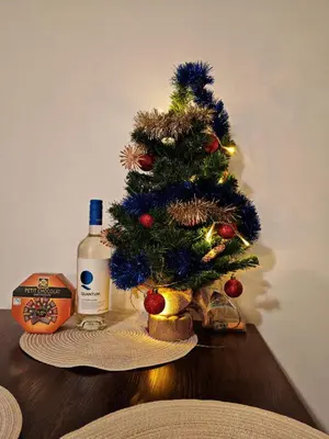 a christmas tree on a table with a bottle of wine at Apartment for guests in Bansko