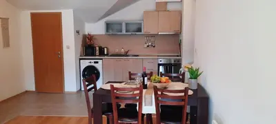 a kitchen with a table and some chairs and a table and a kitchen with at Apartment for guests in Bansko
