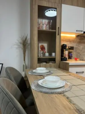 a wooden table with two plates on it in a kitchen at Millennium apartment in Bansko