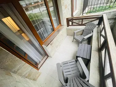 a balcony with two chairs and a bench at Millennium apartment in Bansko
