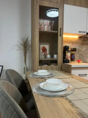 a wooden table with two plates on it in a kitchen at Millennium apartment in Bansko
