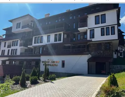 a large white building with a lot of balconies at студио Е 13 in Pamporovo