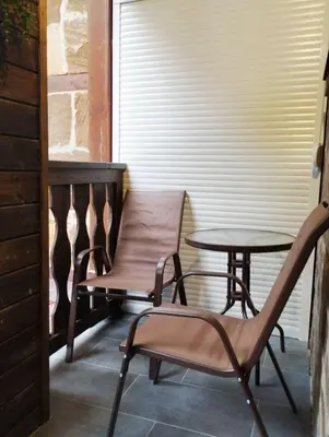 a chair and a table on a porch at студио Е 13 in Pamporovo