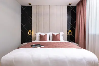 a bedroom with a large white bed with pink pillows at Happy People 2 BD, Central Plovdiv by Flat Mаnager in Plovdiv