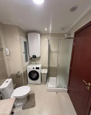 a bathroom with a shower toilet and a washing machine at Daniel's Suite - 4 Season apartment in Bansko