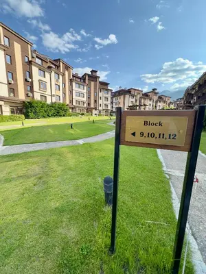 a sign in the grass in front of a building at Daniel's Suite - 4 Season apartment in Bansko